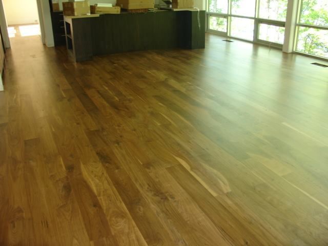 A large room with a wooden floor and lots of windows.