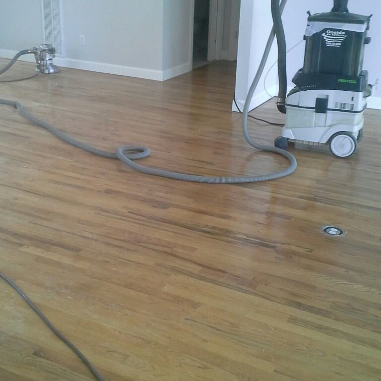 A vacuum cleaner is sitting on a wooden floor.