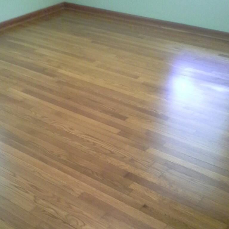 A room with a wooden floor and a white wall.