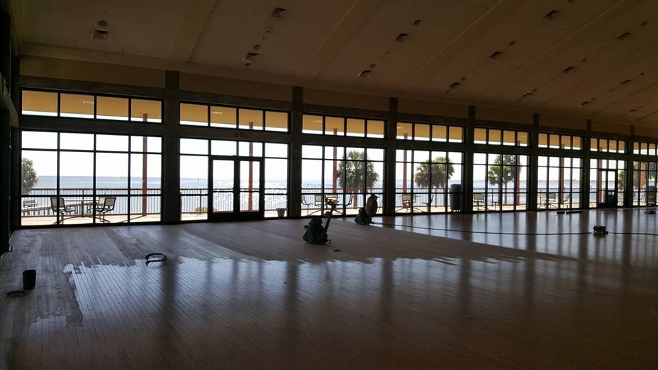 A large room with a lot of windows and a view of the ocean.