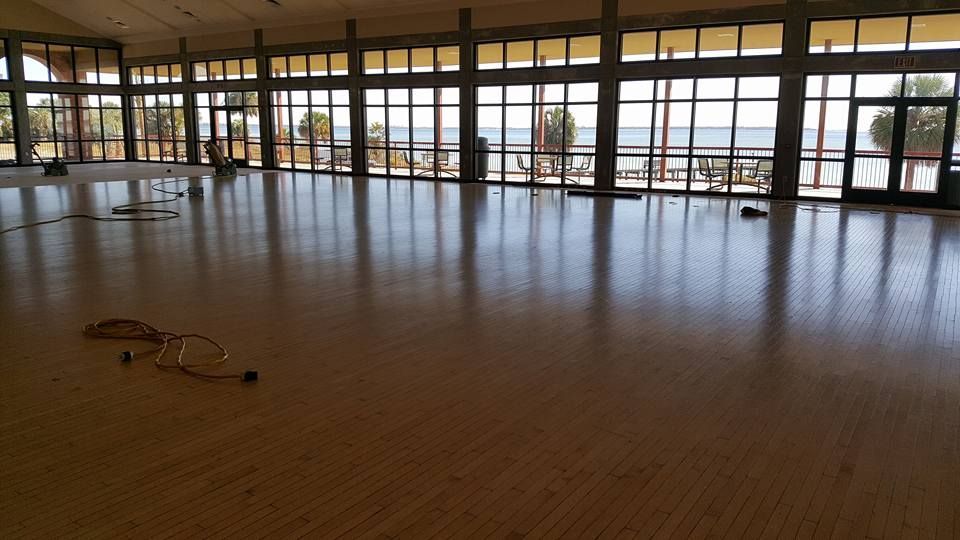 A large room with a lot of windows and a wooden floor.