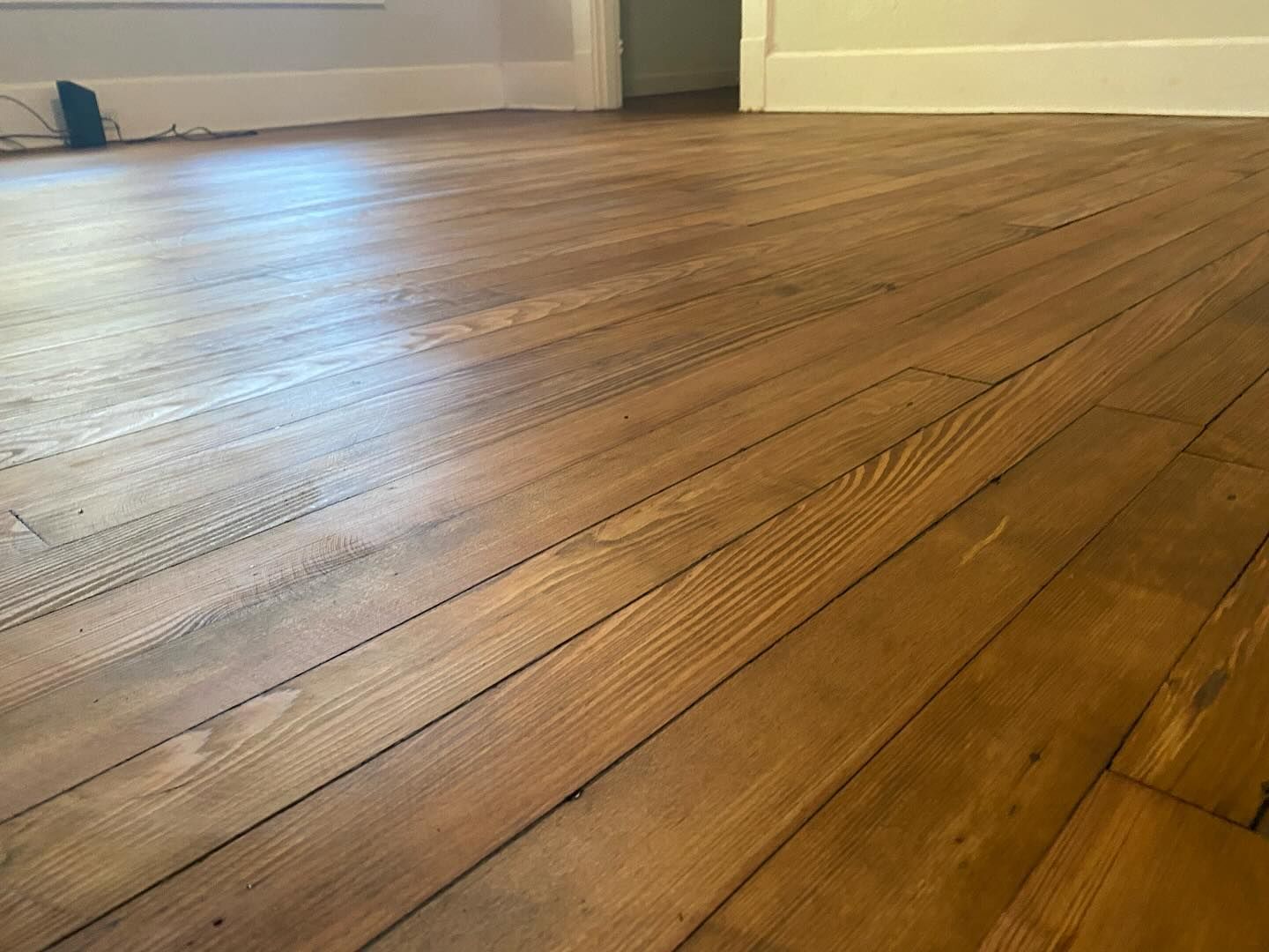 A close up of a wooden floor in a room.