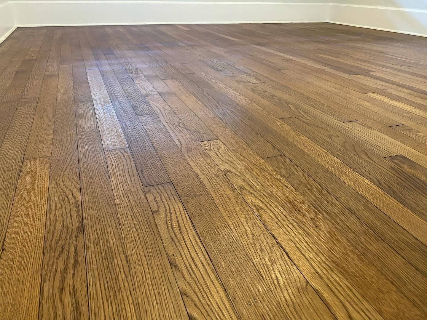 A close up of a wooden floor in an empty room.