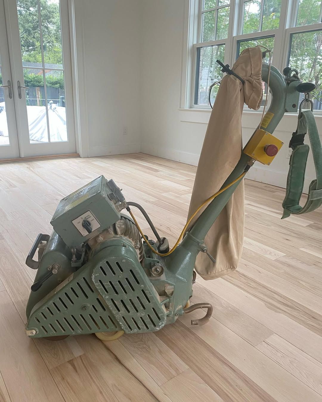A machine is sitting on top of a wooden floor in a room.