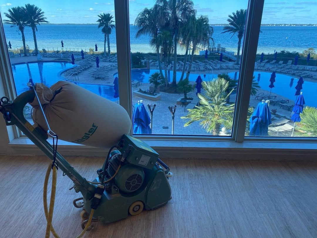 A machine is sitting on a wooden floor in front of a window with a view of the ocean.