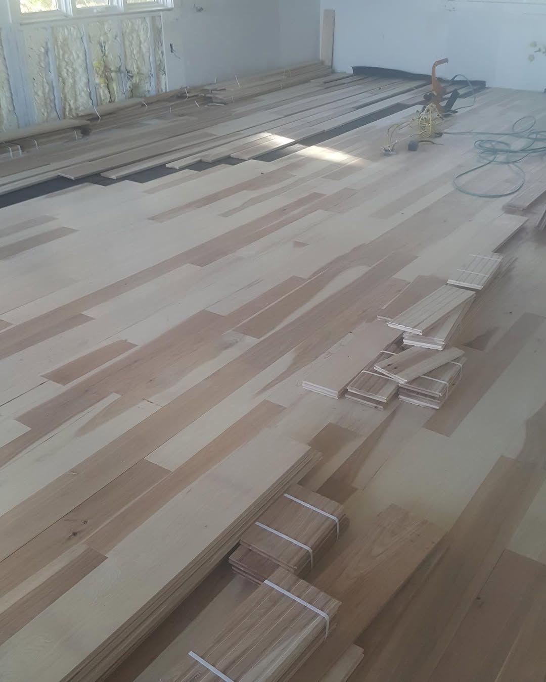 A wooden floor is being installed in a room.