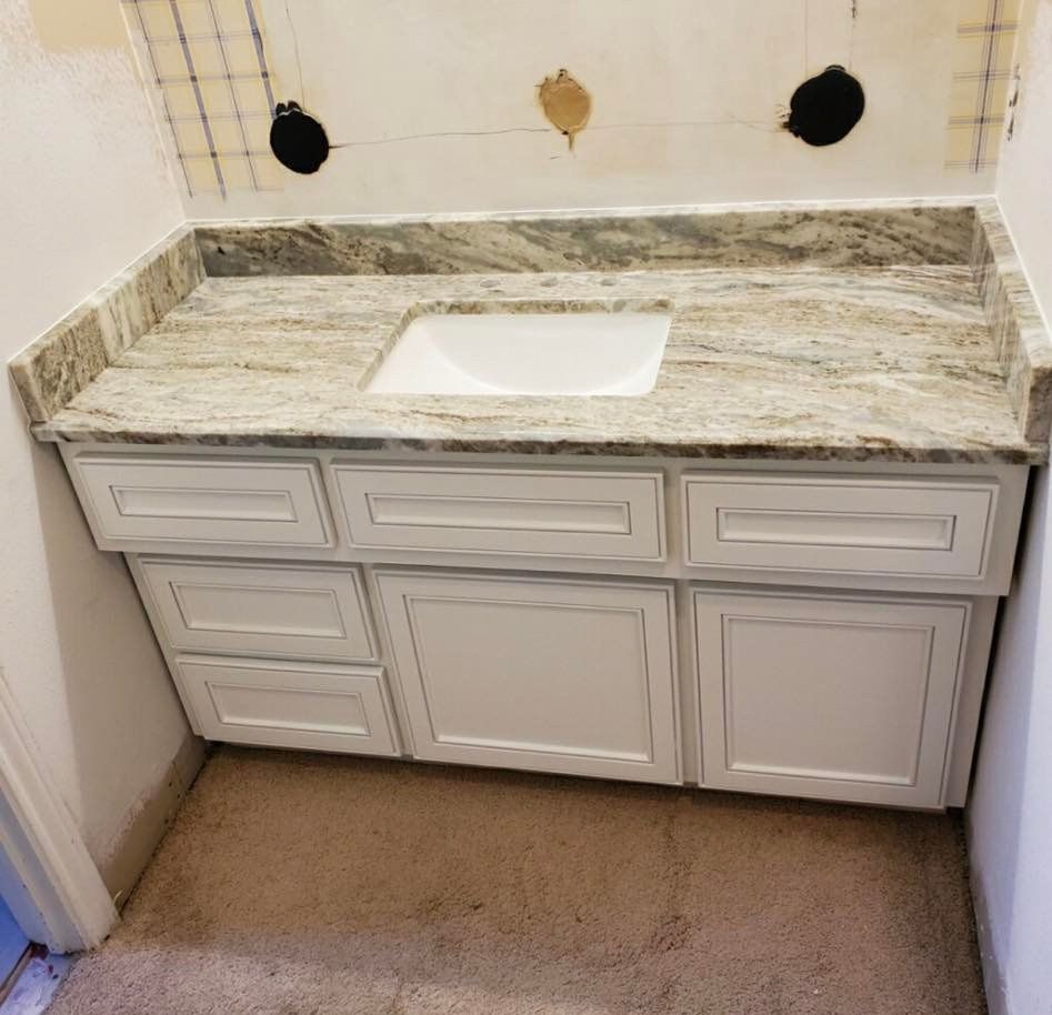 White bathroom vanity with granite countertop and sink.