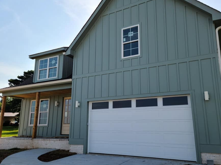 Gray two-story house with white garage door and front porch