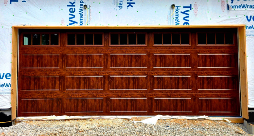 Wooden garage door with horizontal panels set in a white-framed building exterior
