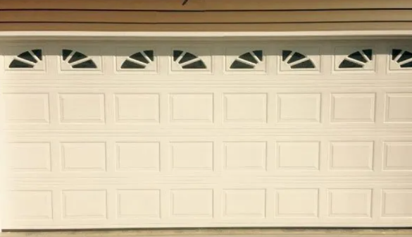White garage door with small arched windows along the top under a beige trim