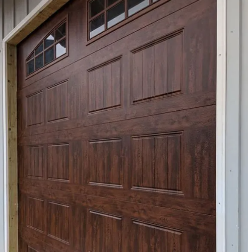 Brown paneled garage door with small window panels at the top left