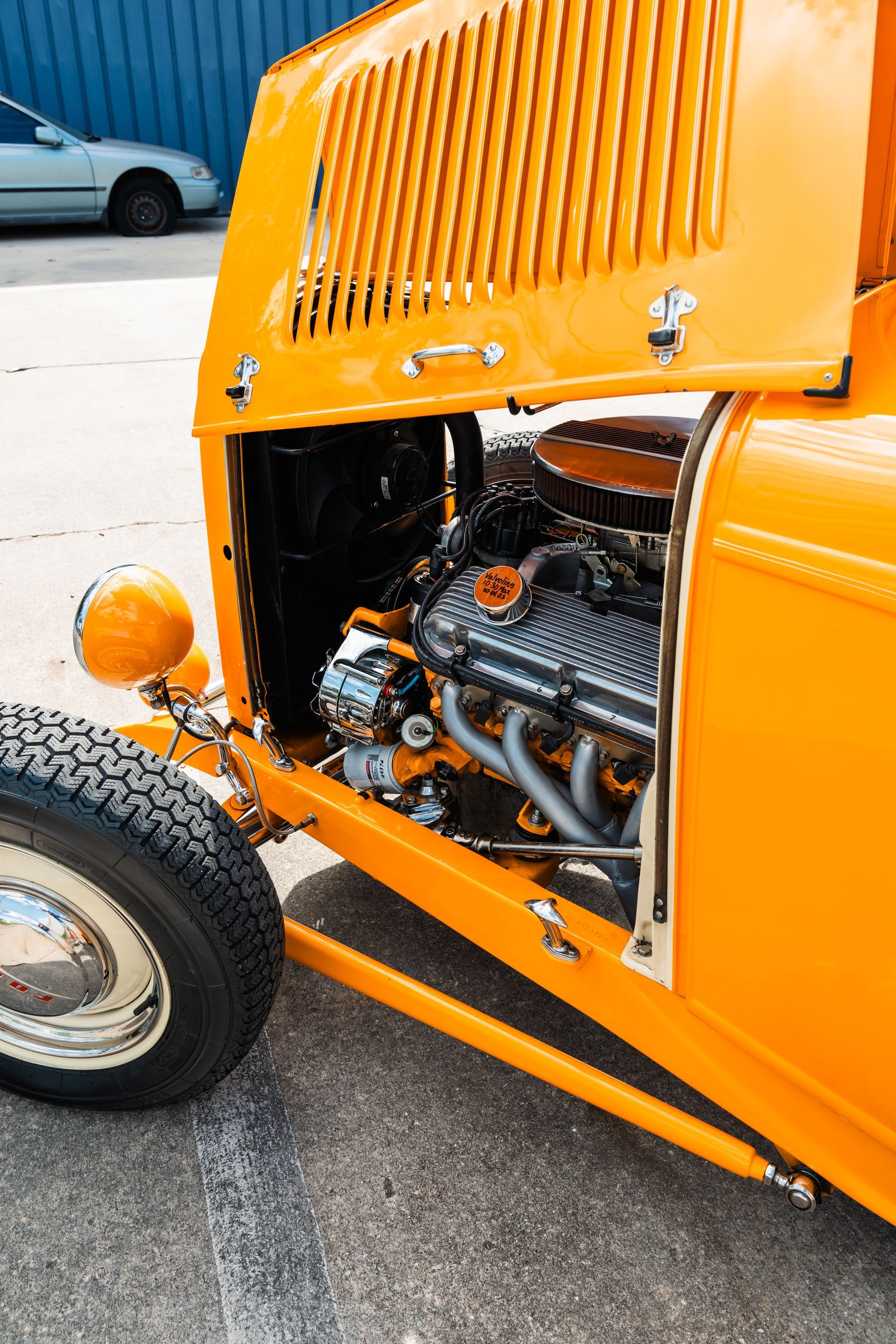 A close up of a yellow car with the hood open.