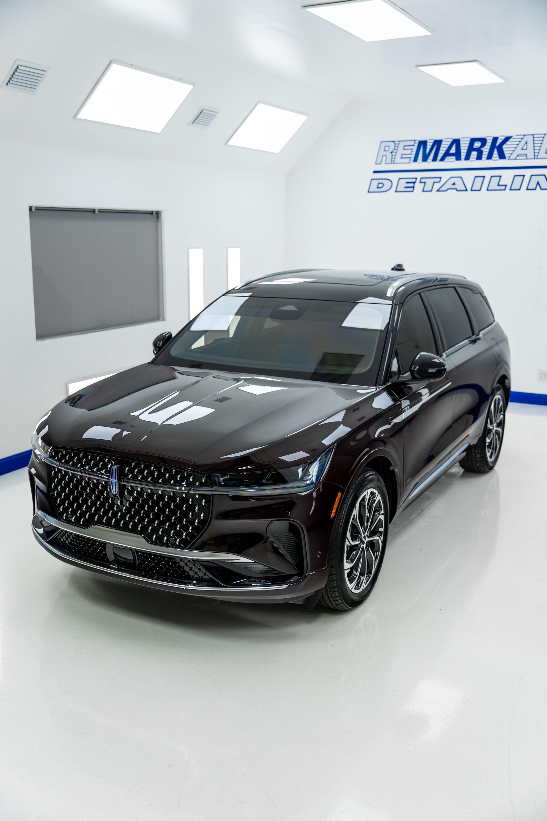 A black lincoln continental is parked in a showroom.