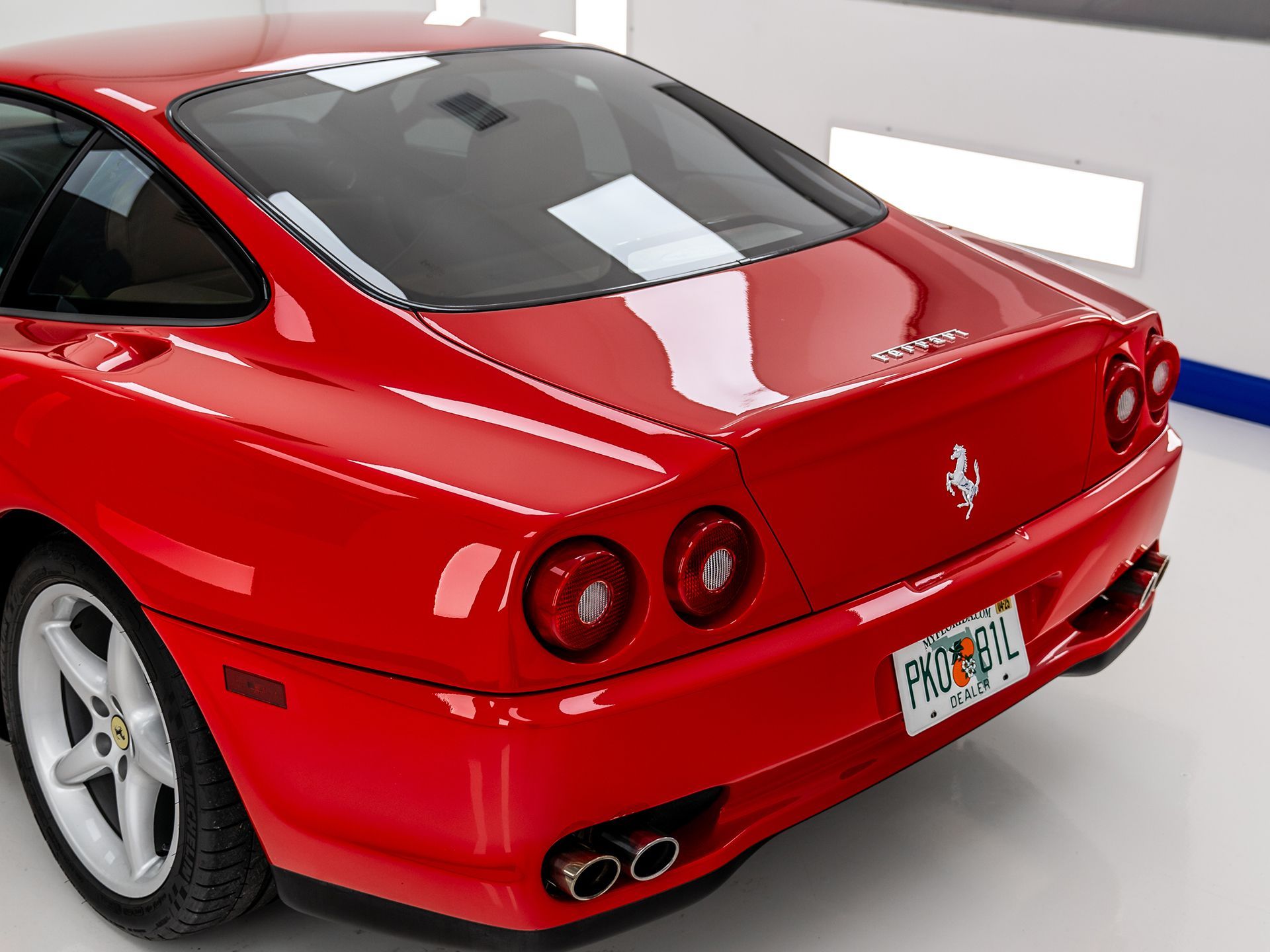 A red Ferrari is parked in a garage