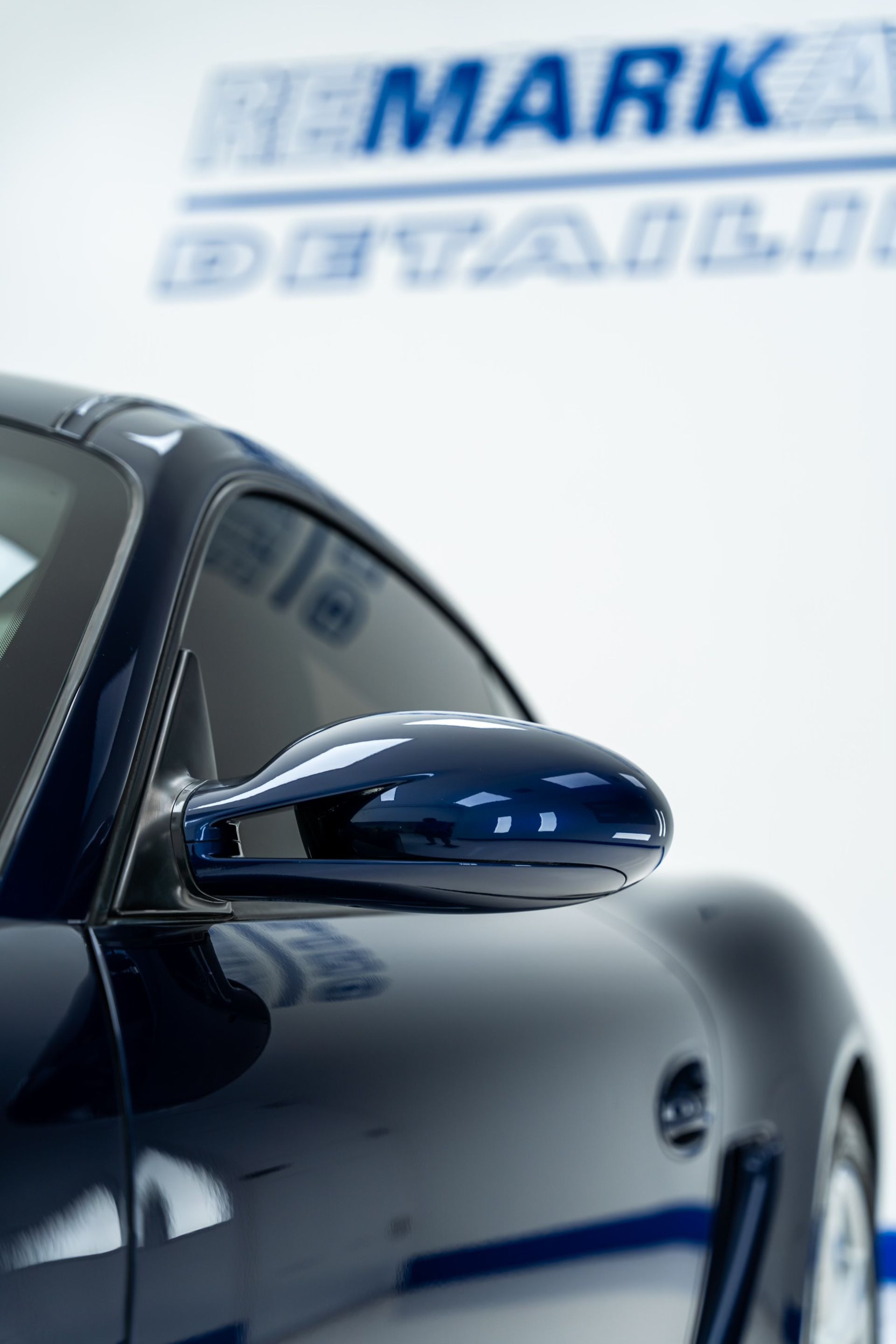 A car is parked in front of a sign that says remarkable detailing