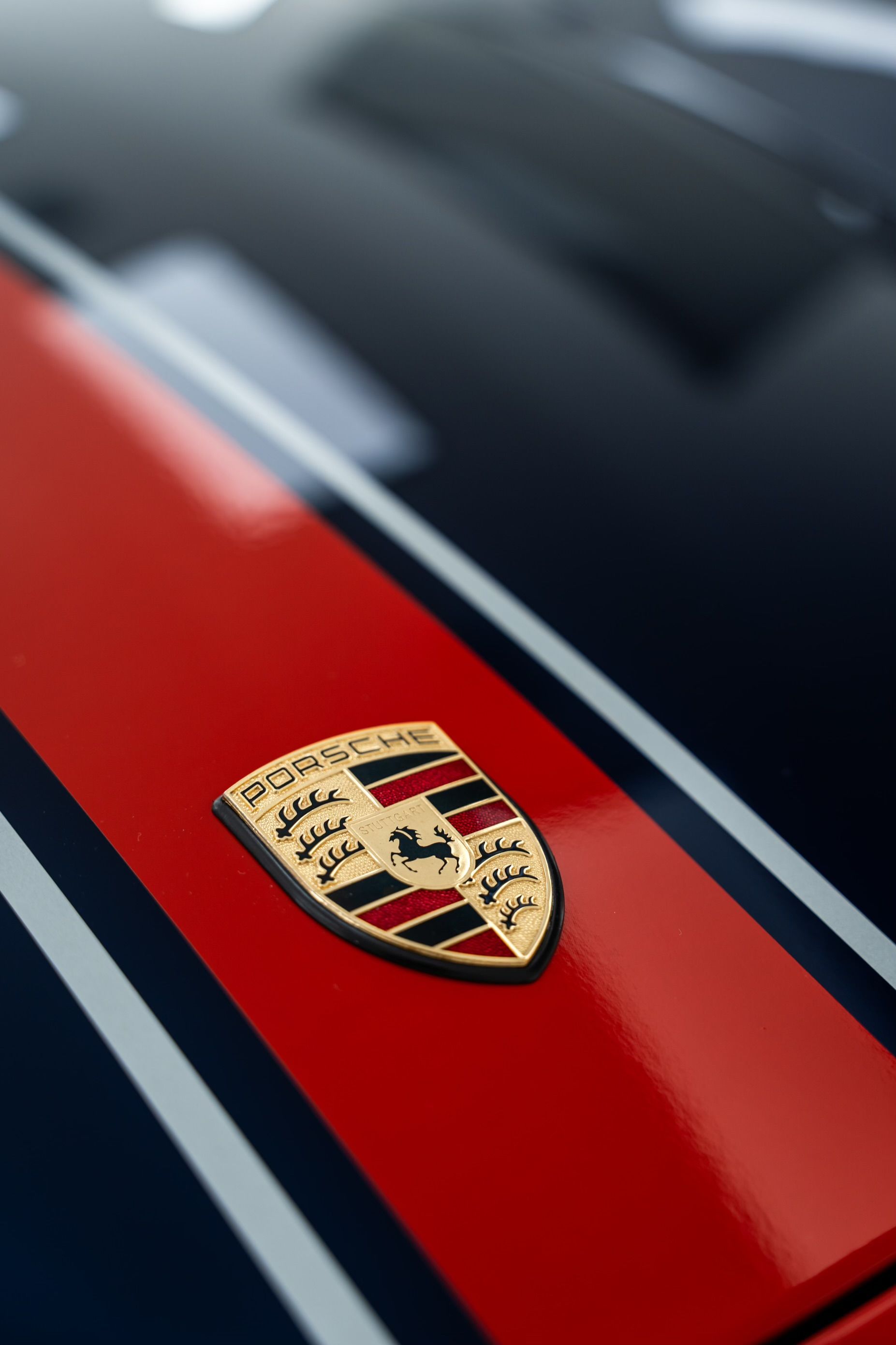 A close up of a porsche emblem on the side of a car