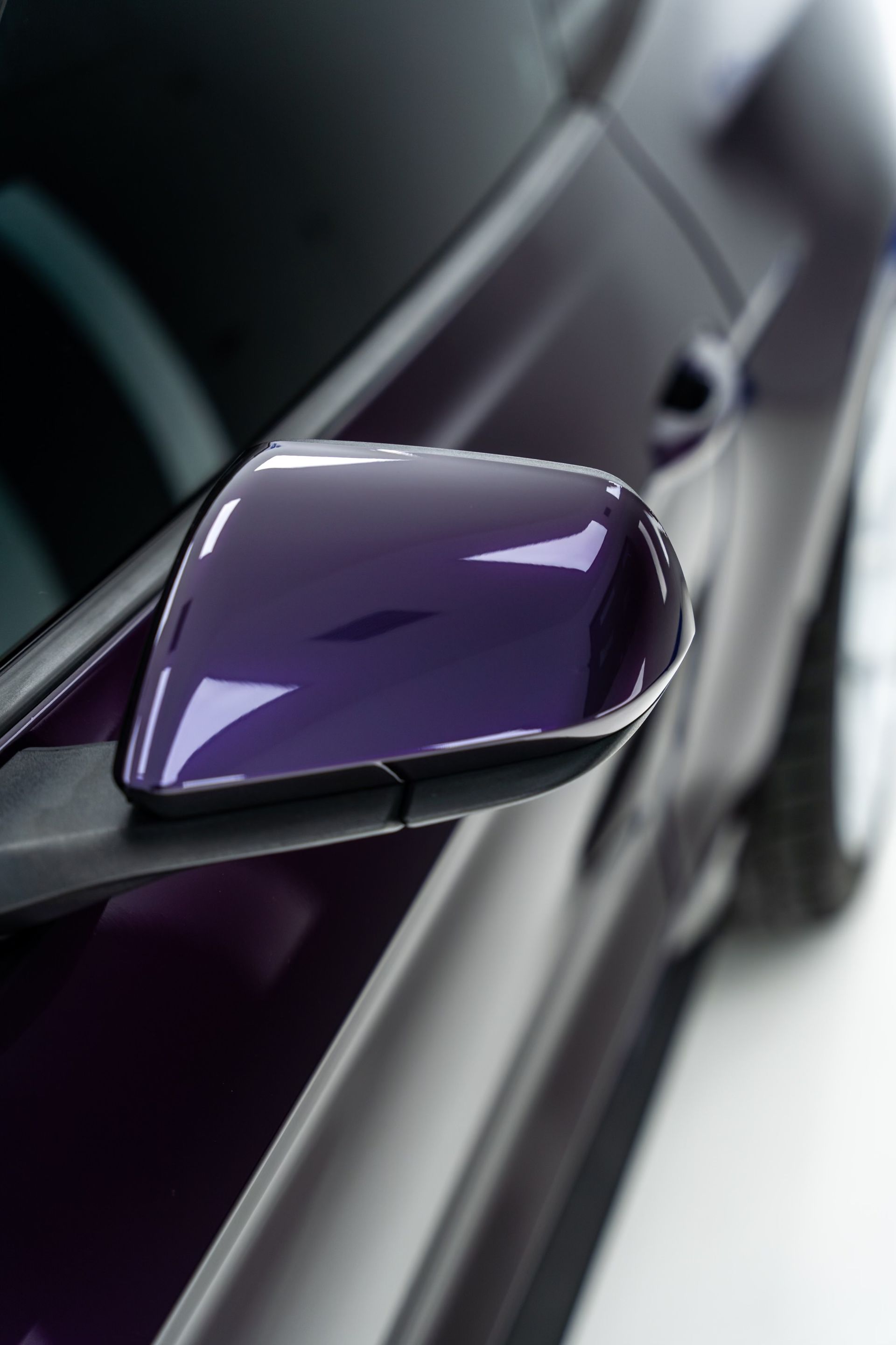 A close up of a purple car 's side mirror