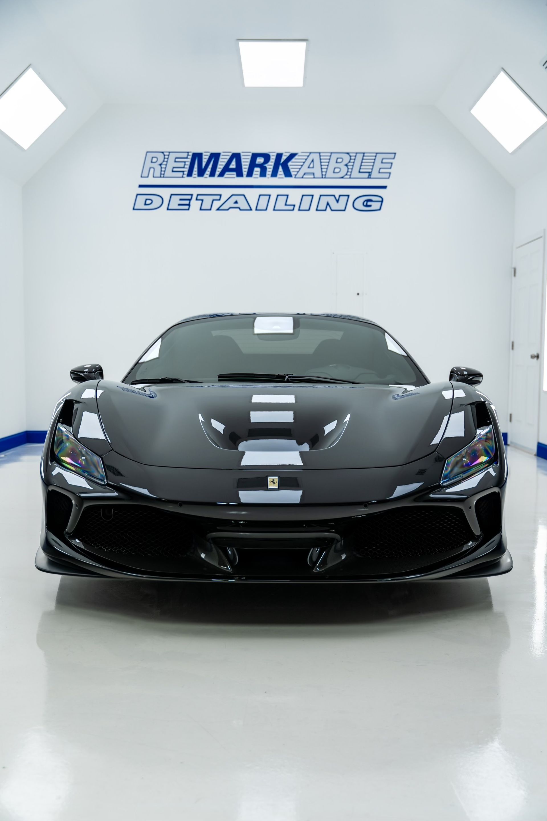 A black sports car is parked in a garage.