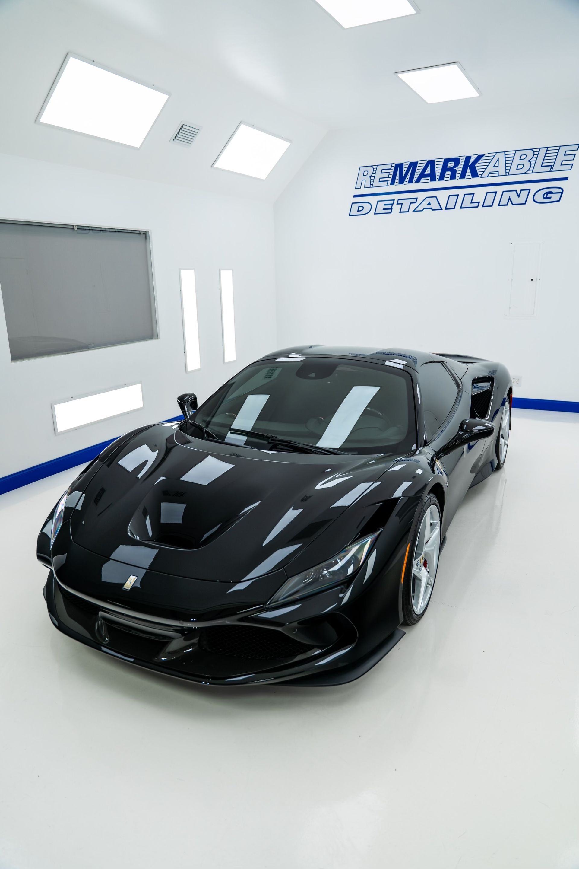 A black sports car is parked in a garage.