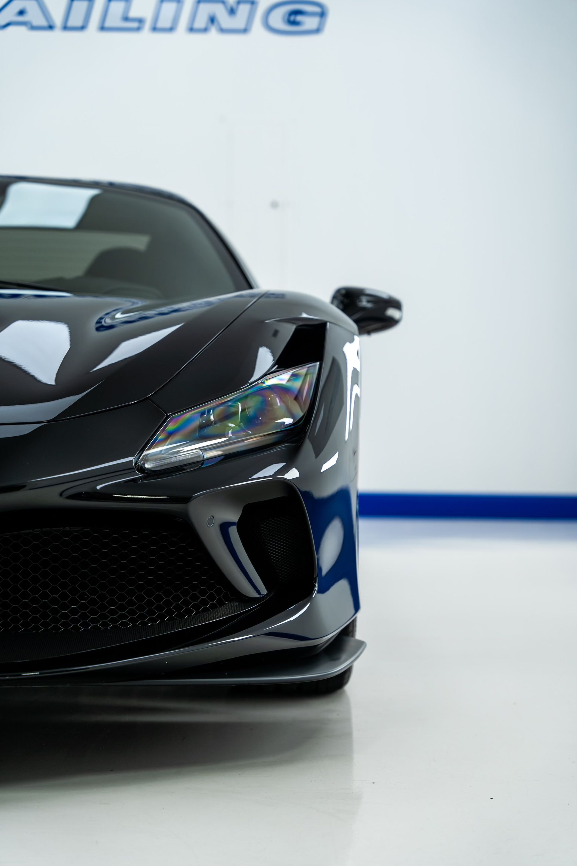 A black sports car is parked in a showroom.