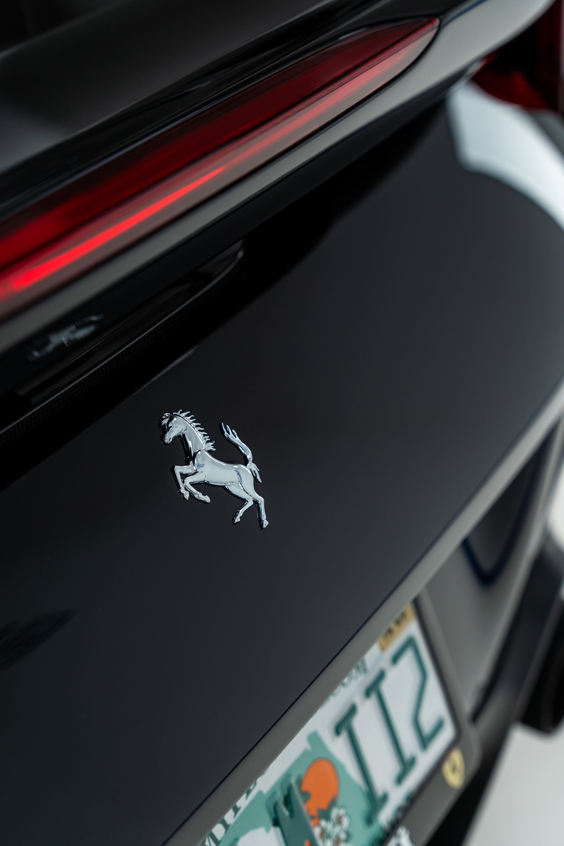 A black ferrari with a license plate that says ii2