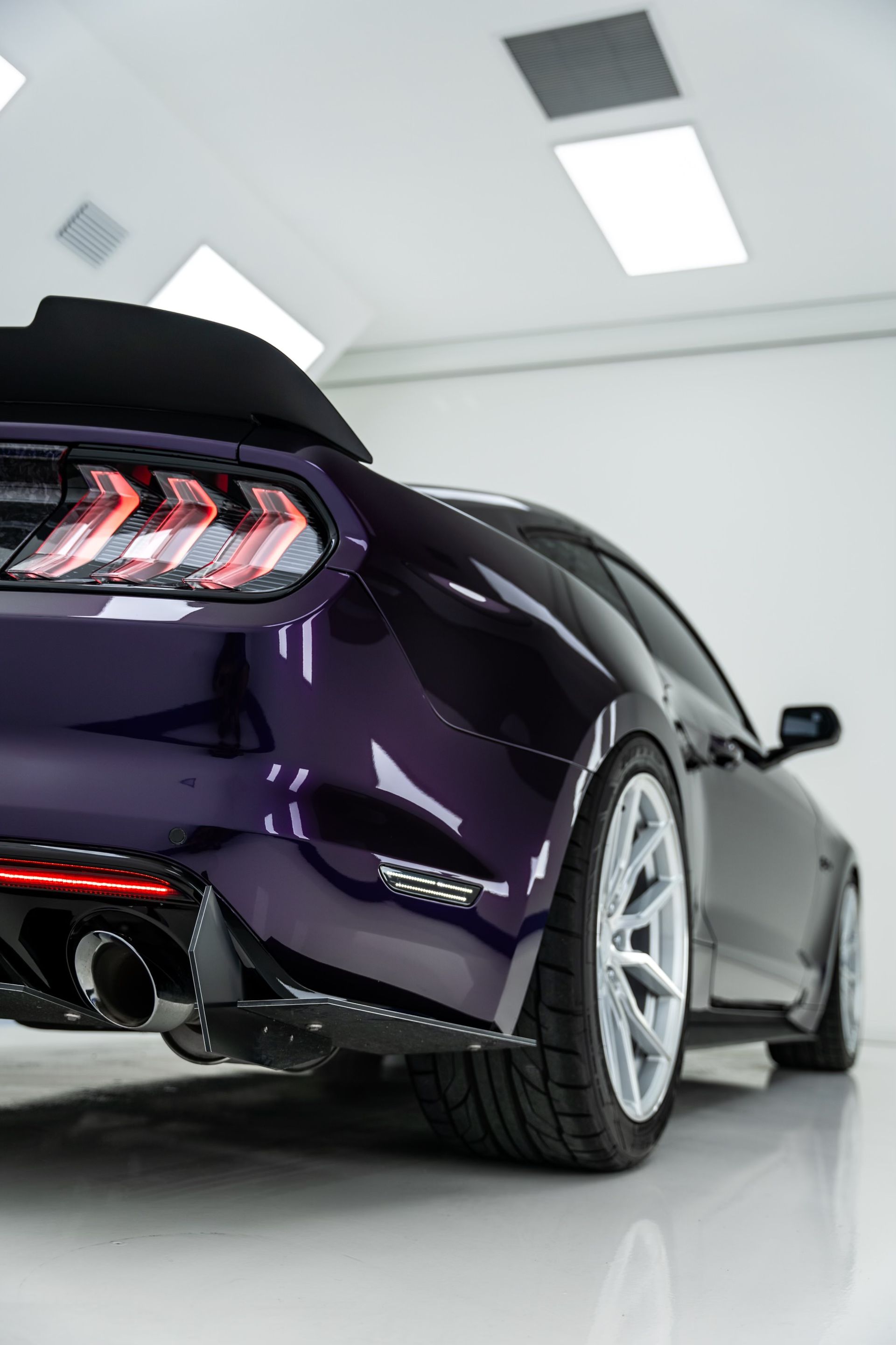 A purple mustang is parked in a garage.