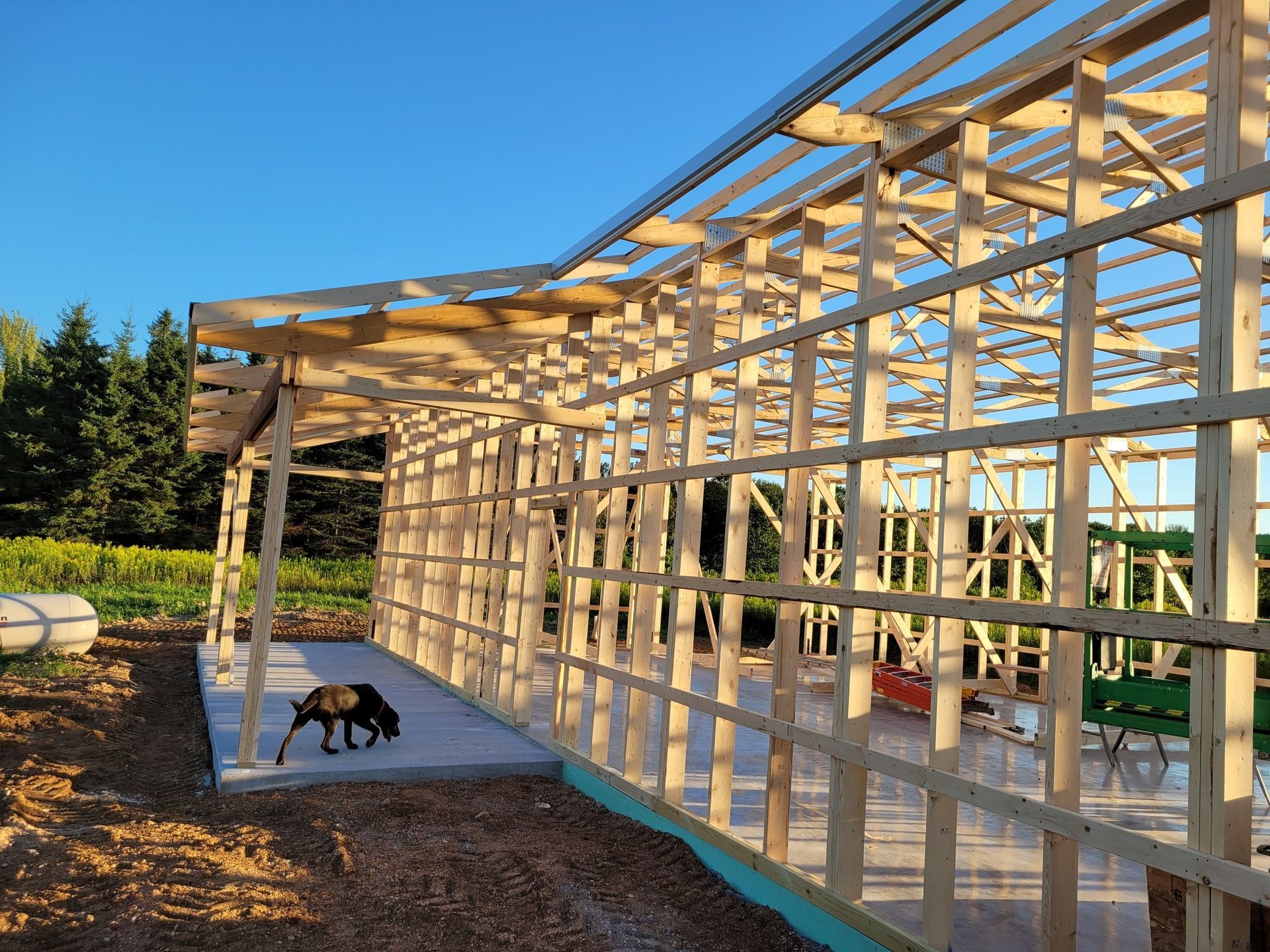 Construction worker reviewing blueprints on a table with a hard hat; construction site in background.