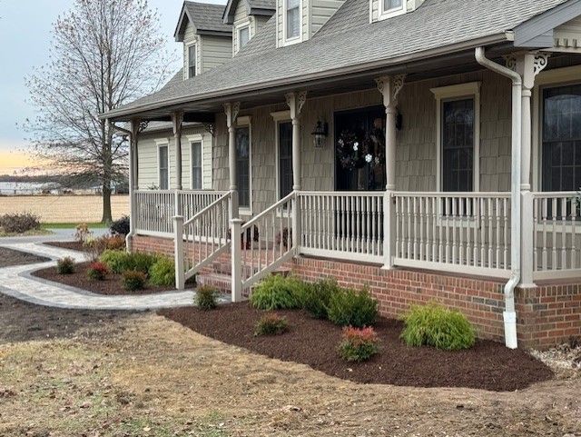 A large house with a porch and a walkway leading to it.