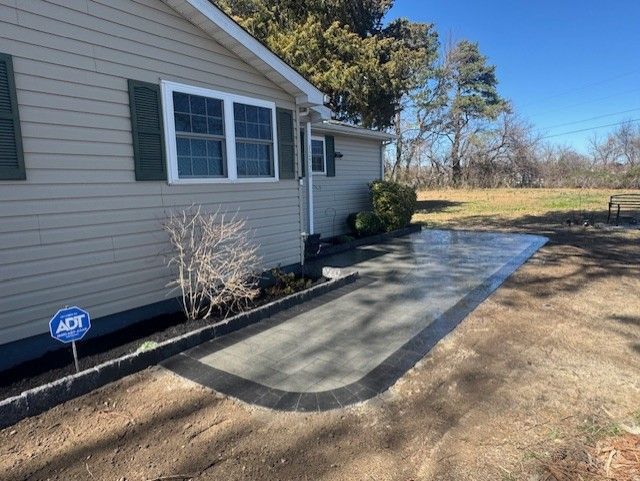 A concrete walkway is being built in front of a house.