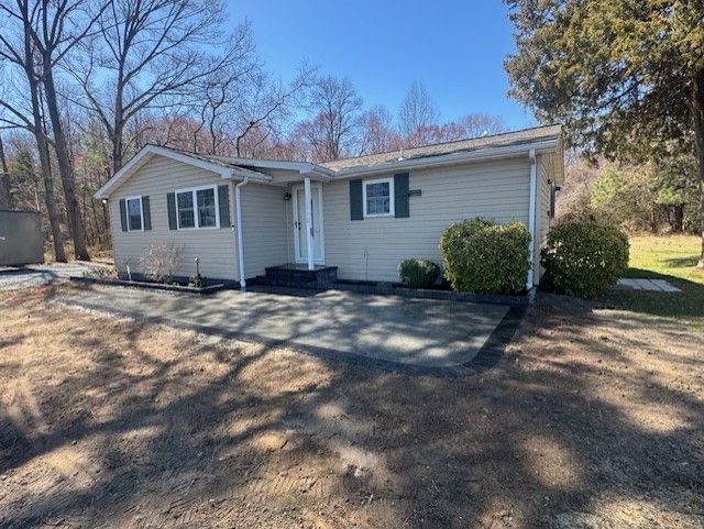 A small white house with a patio in front of it.