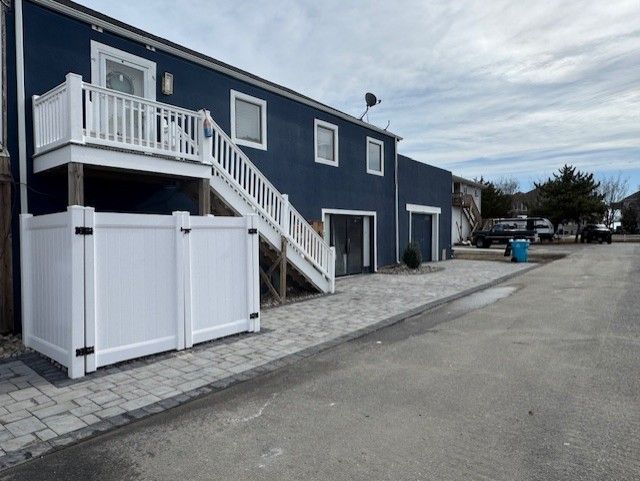 A blue house with white stairs and a white fence