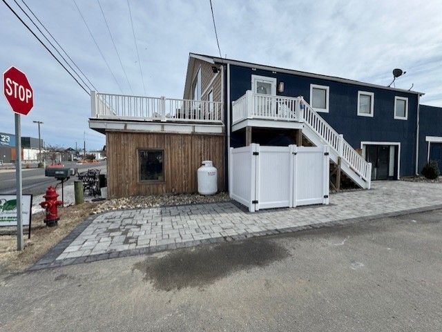 A blue house with a white fence and a stop sign in front of it.