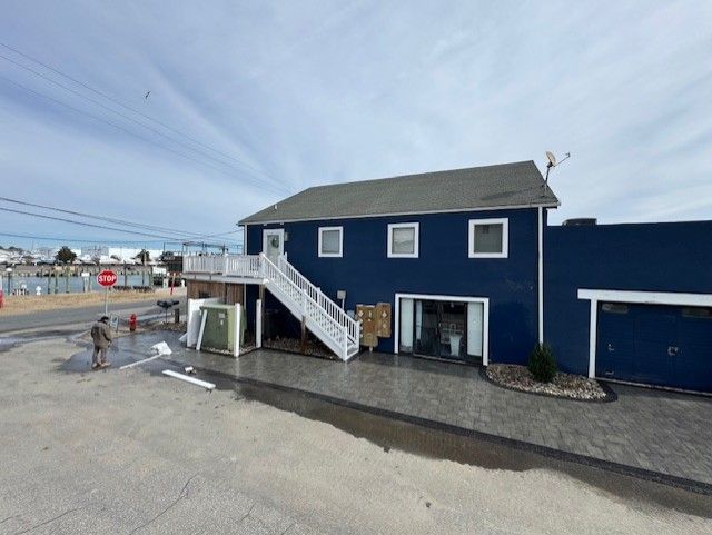 A blue house with stairs leading up to the second floor