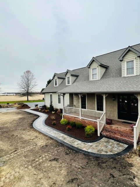 A large white house with a porch and a walkway leading to it.