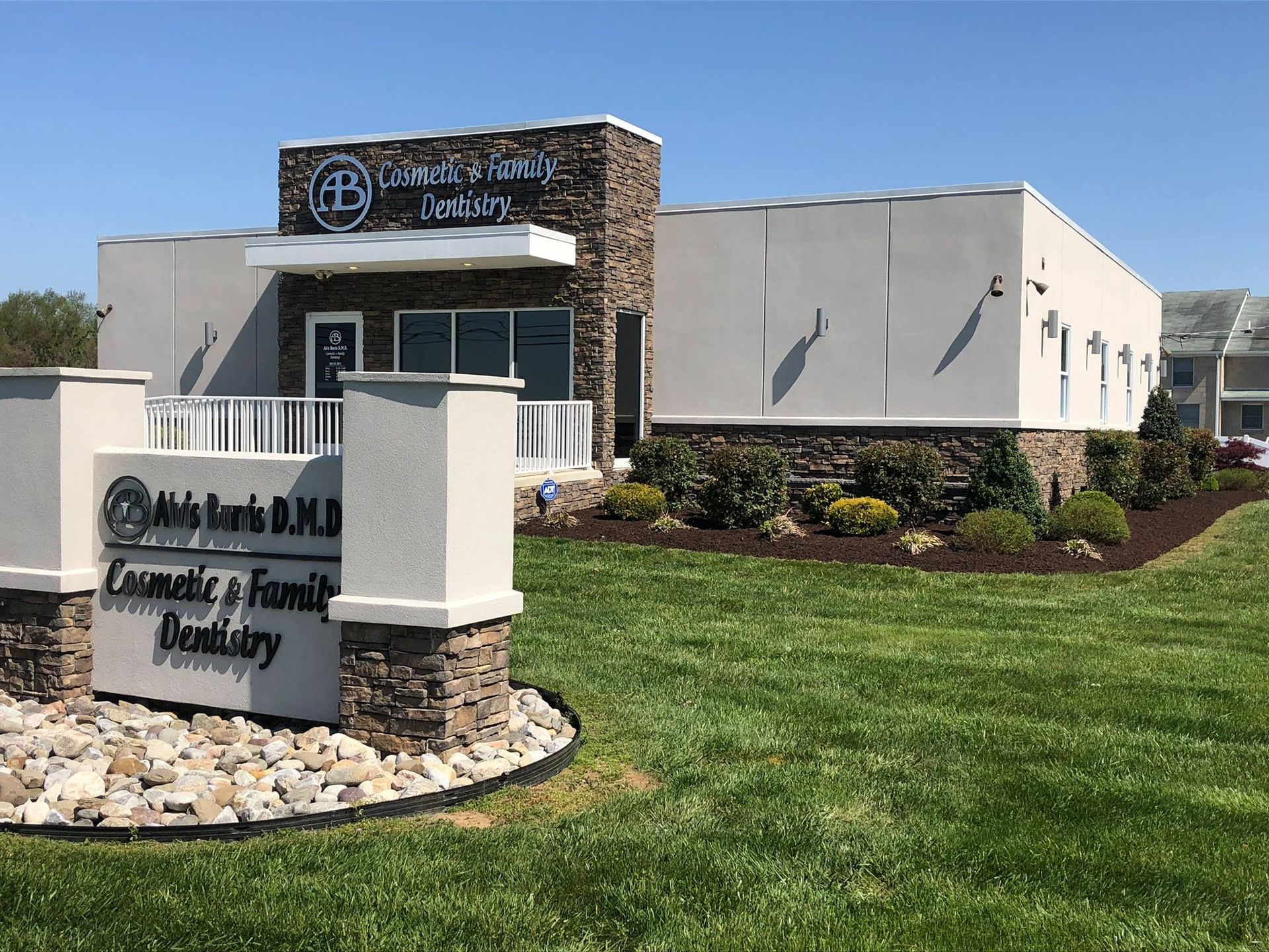 A dental office with a sign in front of it.