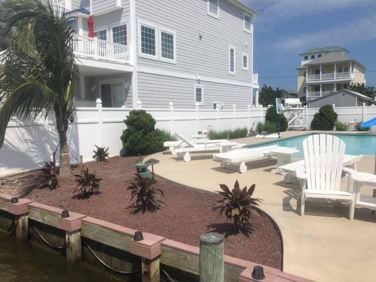 A large white house with a swimming pool in front of it.
