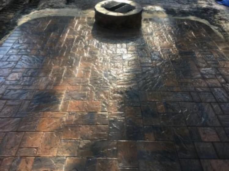 A fire pit is sitting on top of a brick patio.