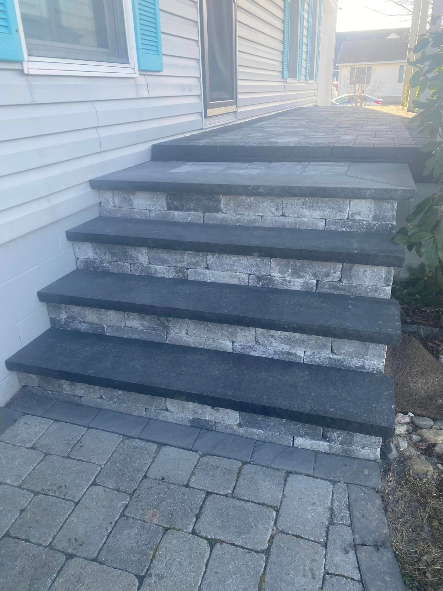 A set of stairs leading up to a porch of a house.
