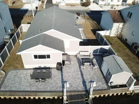 An aerial view of a house with a patio and a dock.