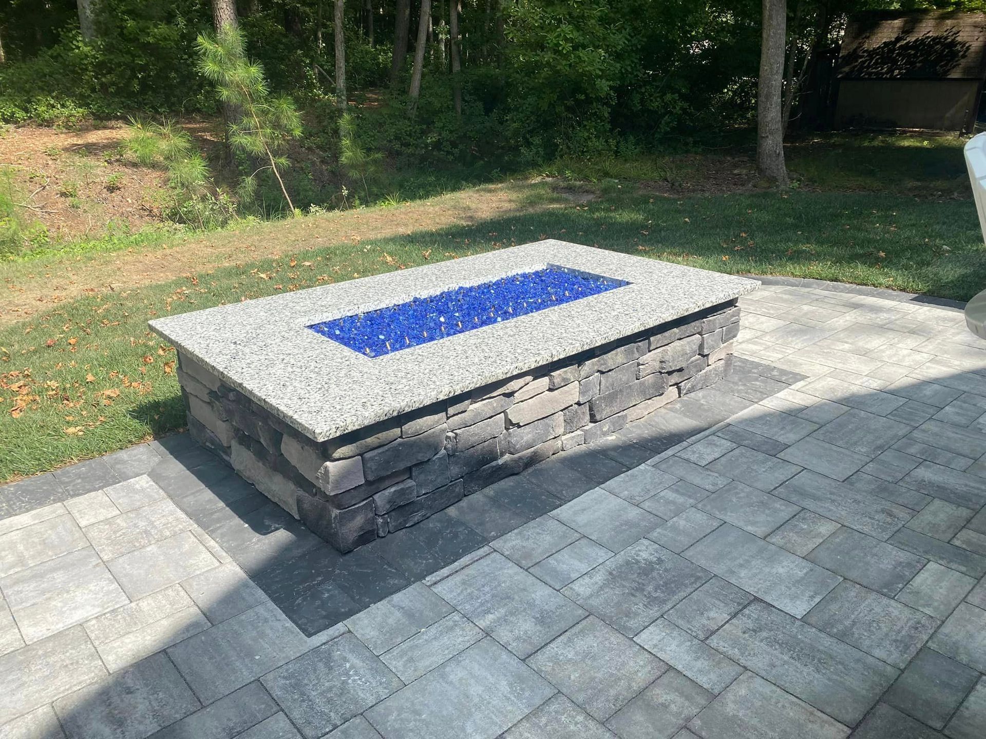 A fire pit is sitting on top of a brick patio.