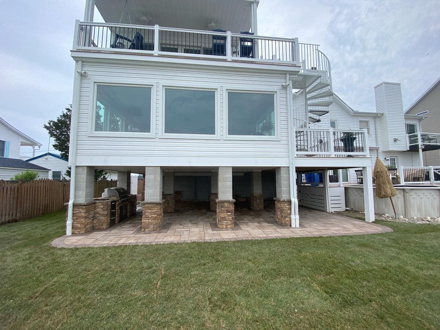 The back of a white house with a spiral staircase.
