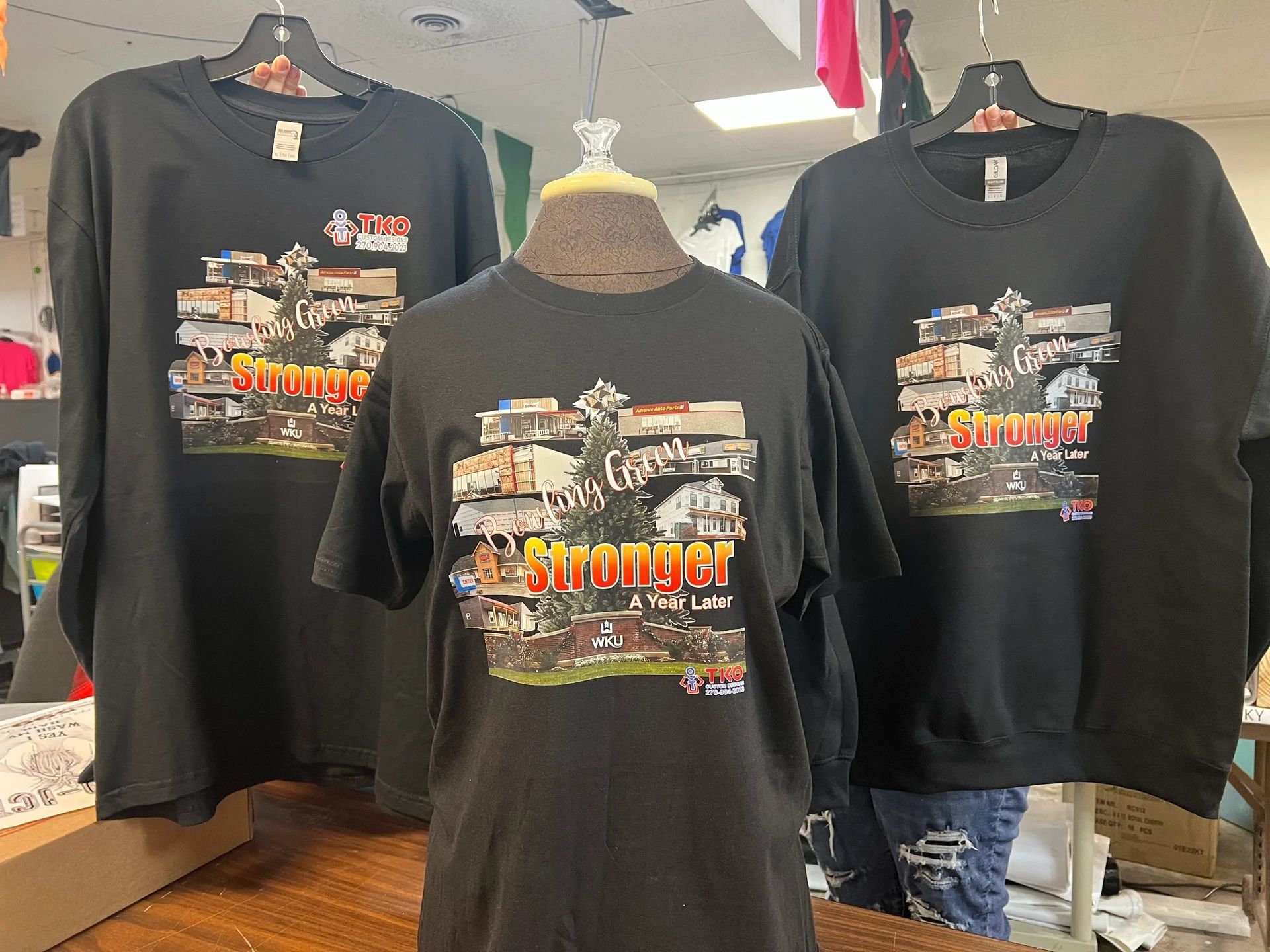 Black graphic T-shirts displayed on mannequins in a clothing store, front and back views