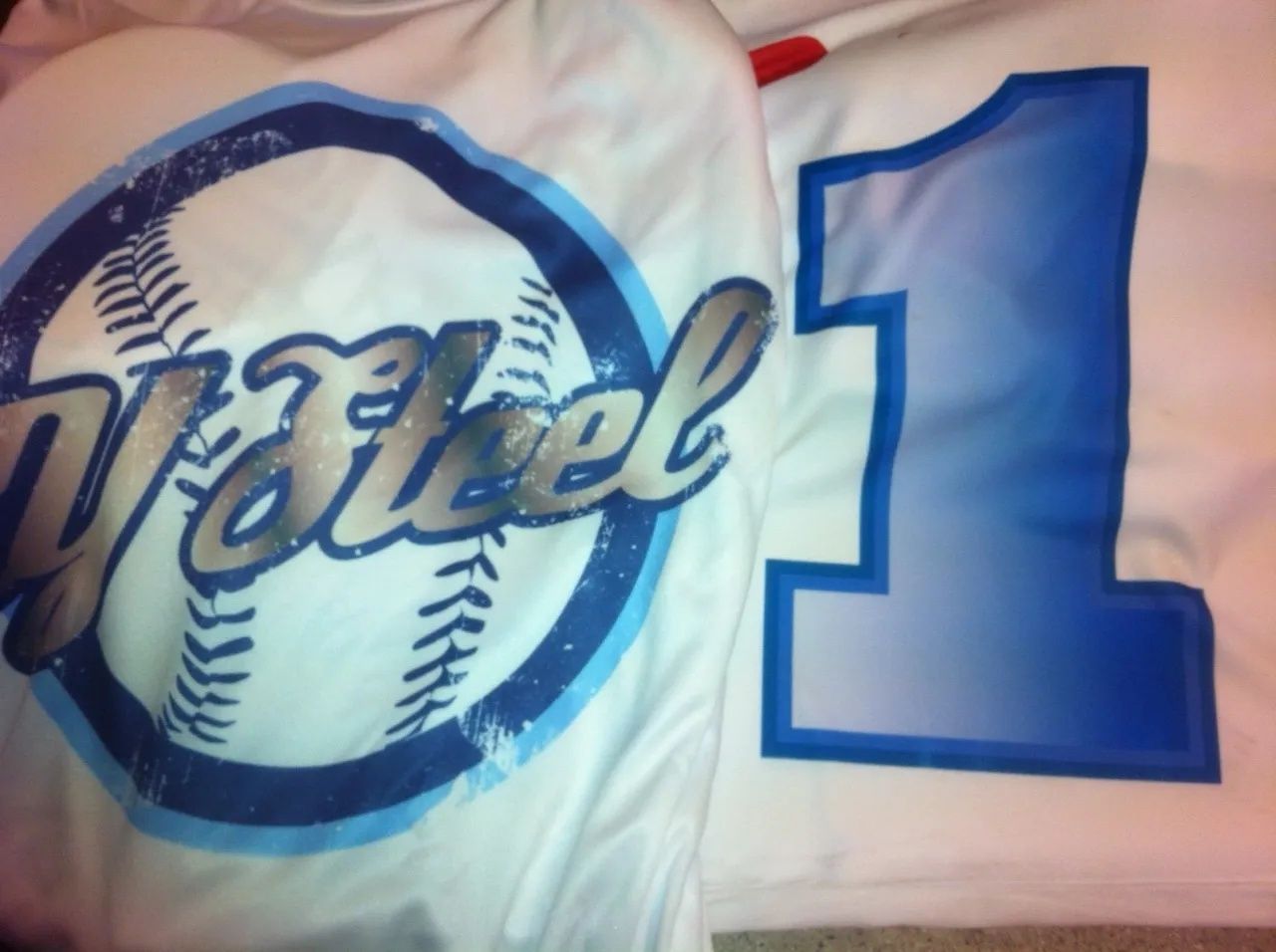 White shirt with a blue baseball graphic and the name “Wiesel,” next to a large blue number 1