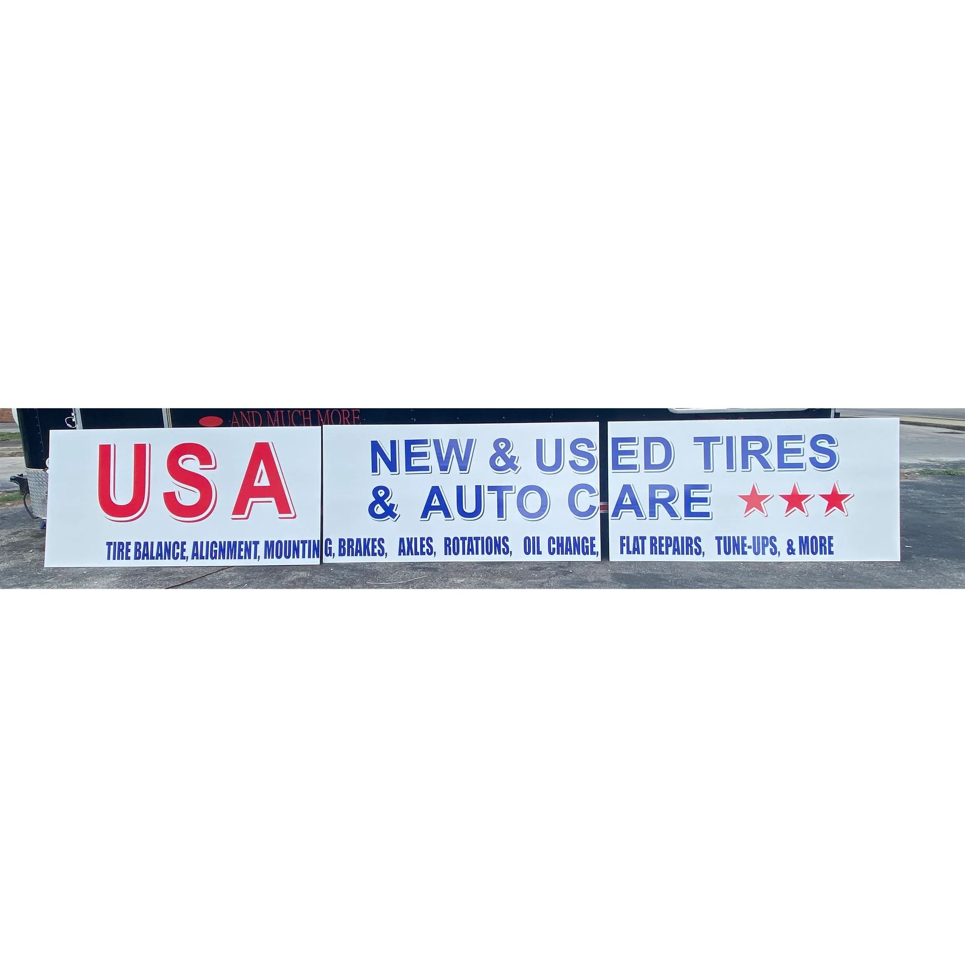 USA sign for new and used tires and auto care, with red stars and blue lettering on a building facade