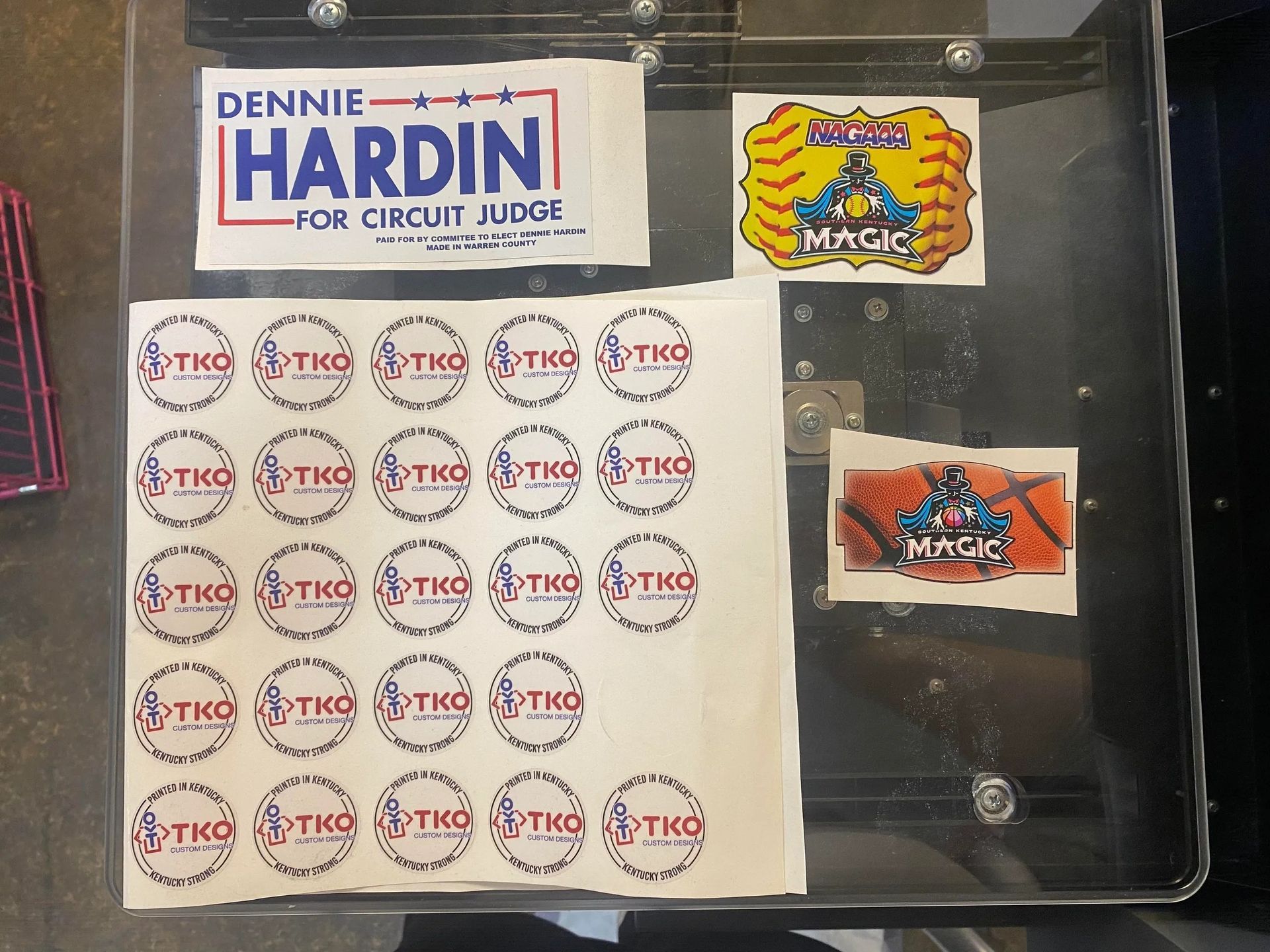 Clear plastic display with Dennie Hardin for Circuit Judge sign, sticker sheet, and two colorful trading card graphics