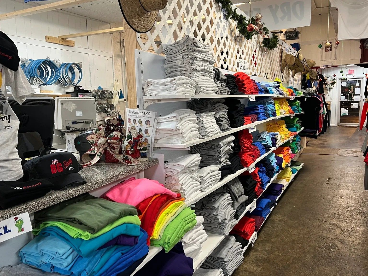 Fabric store aisle with stacked colorful folded towels and shelves of white linens