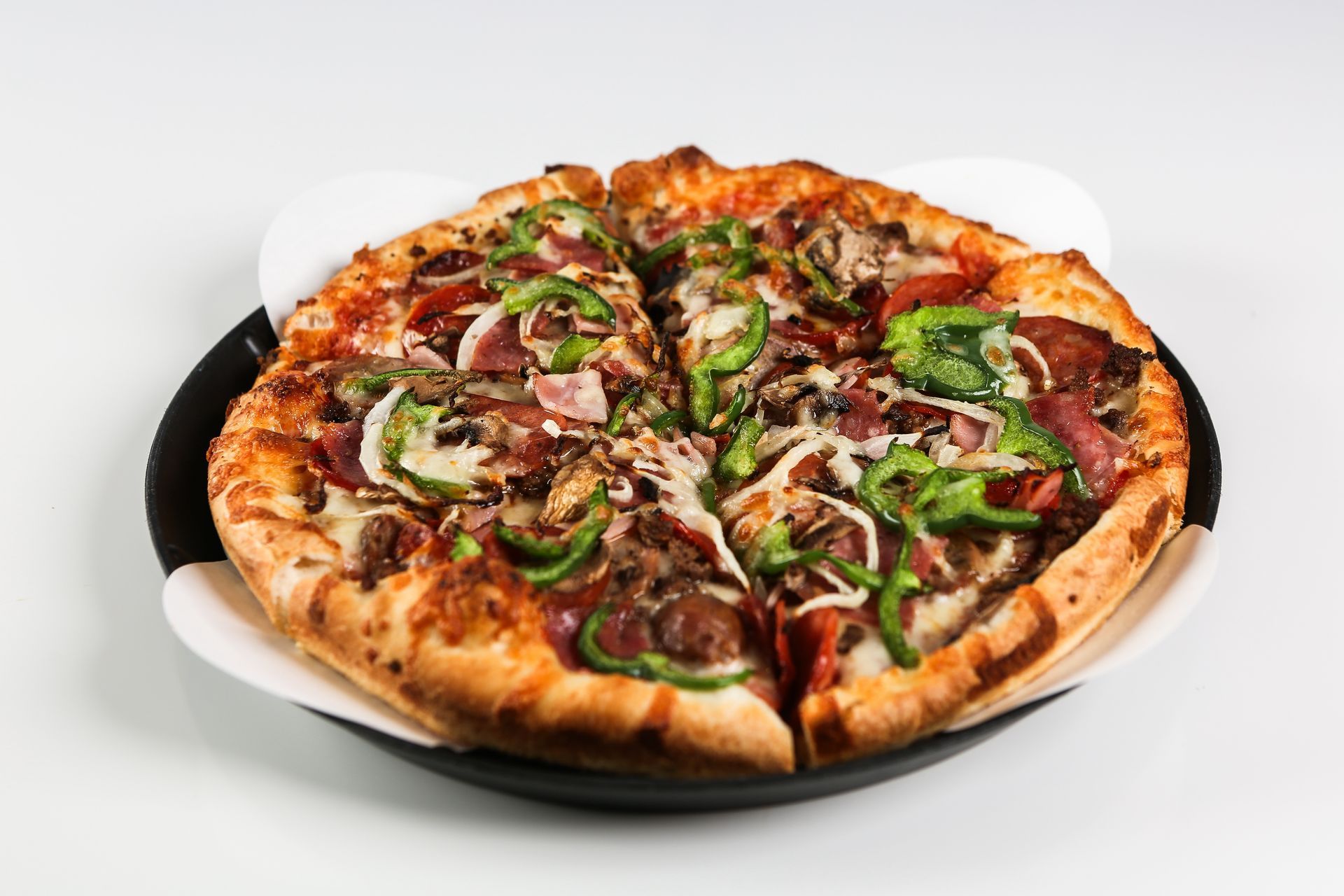 A pizza with a lot of toppings on it on a plate.