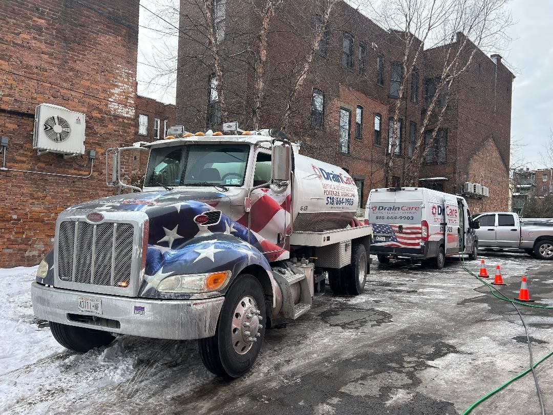 A tanker truck with an american flag painted on the side is parked in the snow.