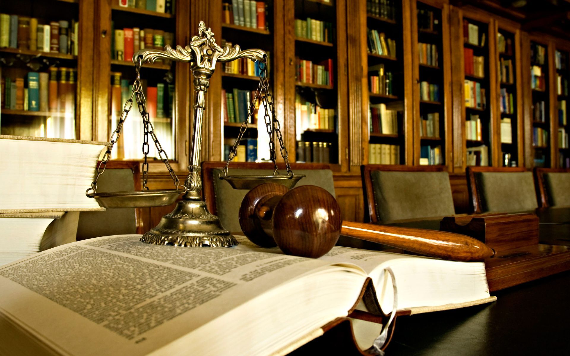 A scale of justice is sitting on top of an open book