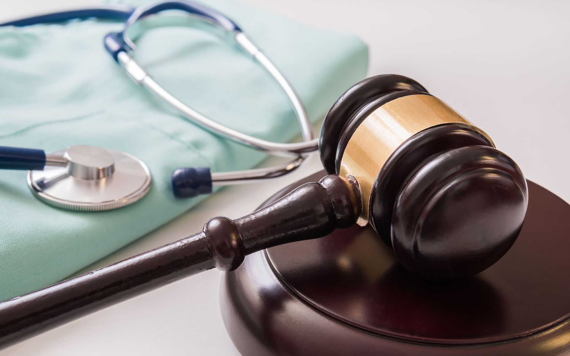 A man and a woman are sitting at a table with a gavel and scales of justice.